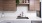 Kitchen sink with wood cabinets above and white counter top