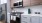 Kitchen with white subway tile backsplash and white counter and a stove