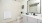 White bathroom with large mirror white counter and toilet