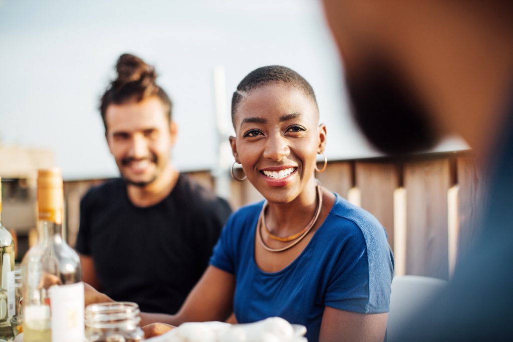 Smiling woman dining with friends on a rooftop