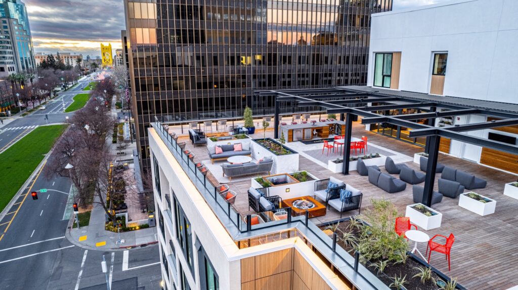 Rooftop outdoor amenity with large tv and capitol in view